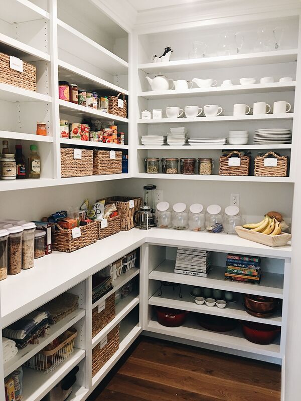 An open kitchen pantry with glossy white acrylic finish shelving.